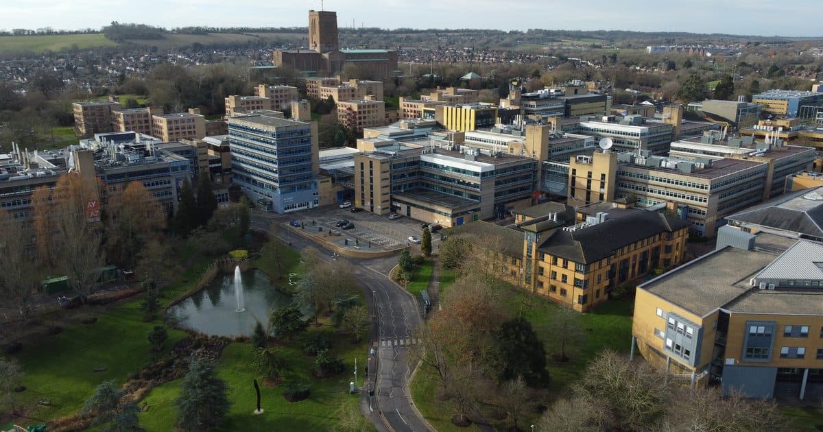Aerial view of the University of Surrey's Stag Hill campus in Guildford, with the lake and Guildford Cathedral behind
