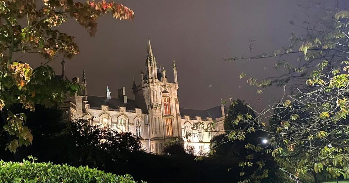 Floodlit Gothic main building of Ulster University's Magee campus in Derry~Londonderry at night