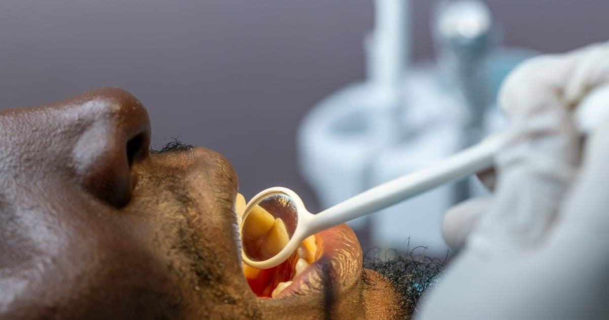 Dentist examining a patient: studying dentistry in the UK as an international student, UK dental schools that accept international applicants, BDS fees and UCAT requirements